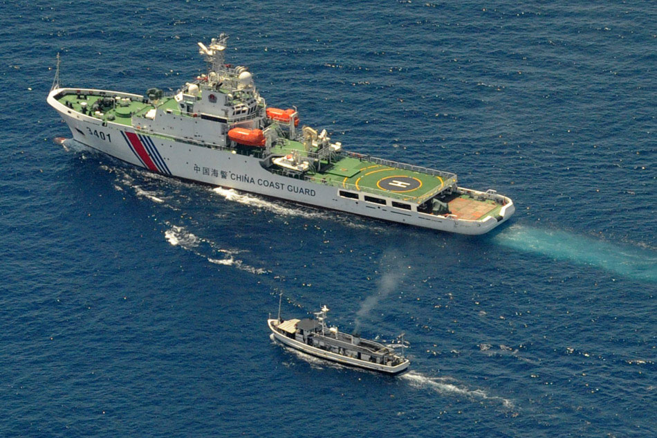 A China Coast Guard ship (top) and a Philippine supply boat engage in a stand off as the Philippine boat attempts to reach the Second Thomas Shoal, a remote South China Sea a reef claimed by both countries, on March 29, 2014. Agence France-Presse