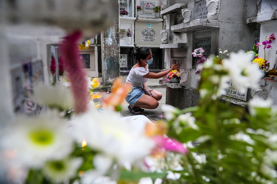 A woman offers prayers and pays respect to loved ones a few hours before authorities proceed with the temporary closure of the Manila North Cemetery in Manila on October 28, 2021 as a precaution against COVID-19. Jonathan Cellona, ABS-CBN News/File