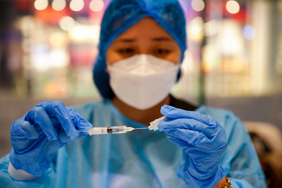 A health worker prepares COVID-19 vaccines inside a mall in Makati City on July 28, 2022. George Calvelo, ABS-CBN News