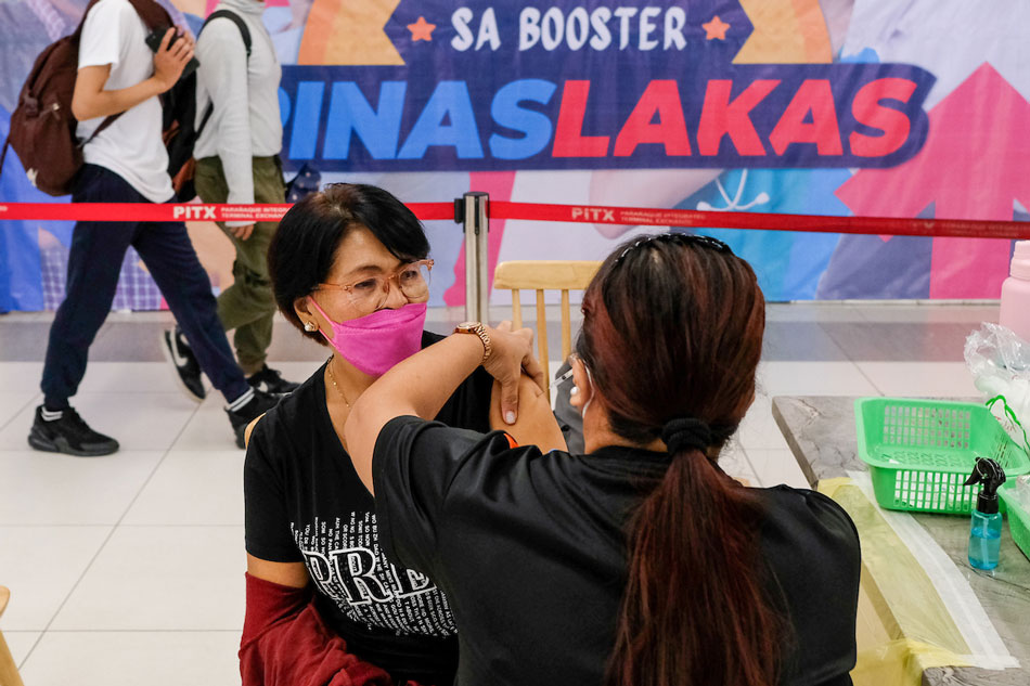A woman receives her first booster shot against COVID-19 at a vaccination site inside the Parañaque Integrated Terminal Exchange on July 27, 2022. George Calvelo, ABS-CBN News/File