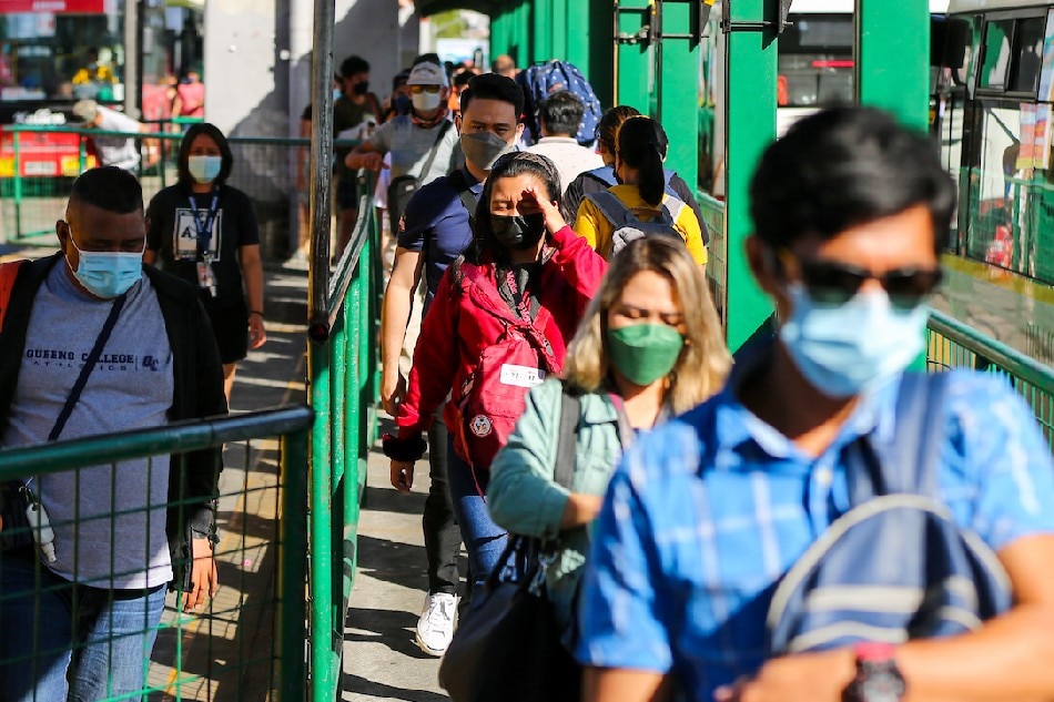 People wearing face masks as a precaution against COVID-19 fall in line at the Monumento bus stop in Caloocan on January 3, 2021. Jonathan Cellona, ABS-CBN New