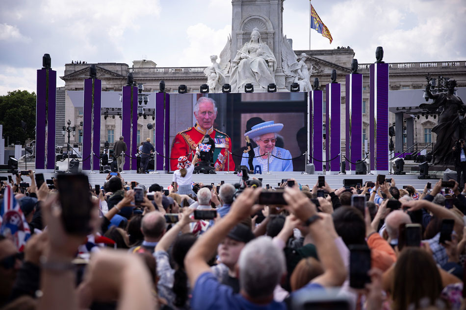 People in the Mall watching Her Majesty, The Queen and The Prince of Wales on the balcony of Buckingham Palace shown on a big screen during the Platinum Jubilee celebrations for Britain's Queen Elizabeth II, in London, Britain, June 2, 2022. Tolga Akmen, EPA-EFE/File 