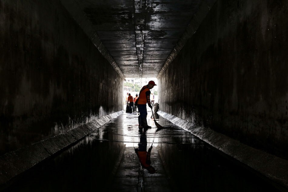 Workers from the Department of Public Works and Highways (DPWH) clear mud from a tunnel along riverside drive in Las Piñas on September 9, 2021. Tropical Storm Jolina brought in heavy rains that caused waist-deep flooding in the area yesterday. George Calvelo, ABS-CBN News