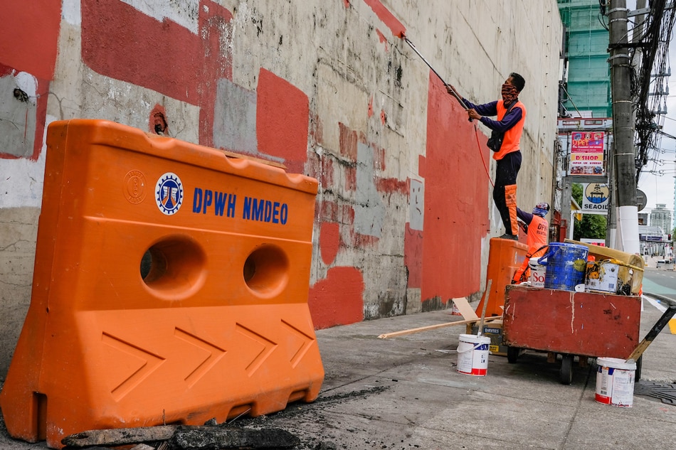 Workers from the Department of Public Works and Highways (DPWH) repaint walls along the roads near Malacañang Palace in Manila on June 29, 2022. George Calvelo, ABS-CBN News/File