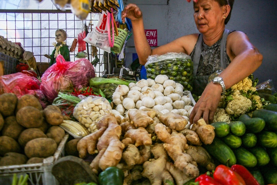A vendor tends to her vegetable stall at the Bustillos market in Manila on August 16, 2022. Jonathan Cellona, ABS-CBN News