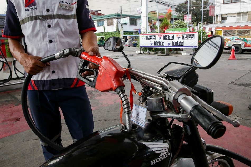 A gas station clerk refills a tricycle’s tank at a station in Manila on March 15, 2022. George Calvelo, ABS-CBN News