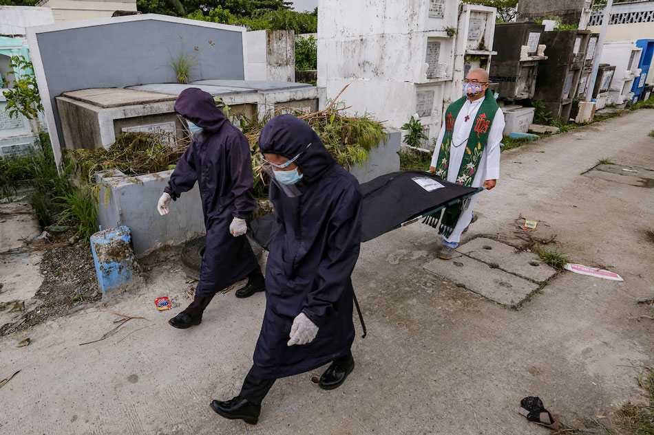Fr. Flavie Villanueva along with workers carry the exhumed remains of Aljon Deparine at the Navotas Cemetery on September 17, 2021. George Calvelo, ABS-CBN News