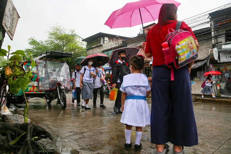 Highschool students walk along Dagat-dagatan Street in Caloocan City on Sept. 19, 2022 after classes as the monsoon season brings sudden torrential rains in the metro. Jonathan Cellona, ABS-CBN News 