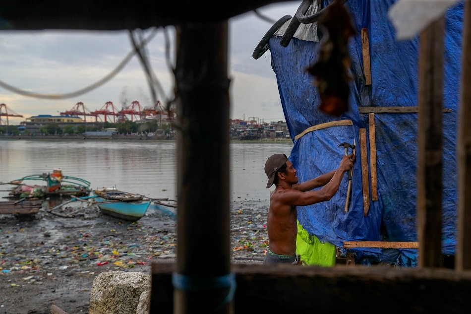 A resident uses plastic sacks and scrap wood as he strengthens a shanty to help make it withstand the storms in Baseco Community in Tondo Manila on June 11, 2021. Jonathan Cellona, ABS-CBN News/file