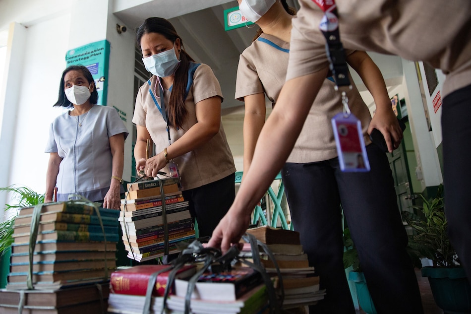 Teachers gather donated books as the Alliance of Concerned Teachers (ACT) launched Tulong Guro donation drive and relief operations to assist teachers and learners in Sta. Lucia High School in Quezon City on Sept. 27, 2022. ACT, together with donors, distributed ‘baon packs’, school supplies, hygiene kits, and used books for the school to use in the aftermath of super typhoon Karding. George Calvelo, ABS-CBN News/File