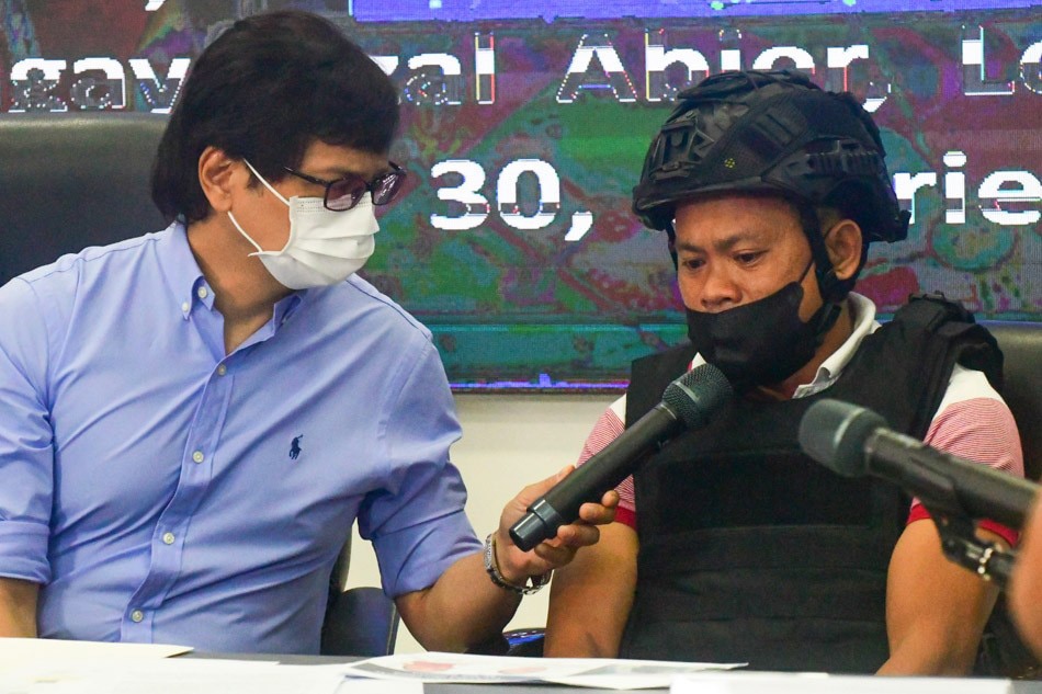 Joel Estorial (right), the suspected gunman in the murder of broadcaster Percy Lapid, talks to Interior Secretary Benjamin Abalos Jr. after surrendering to authorities on Oct. 18, 2022. Mark Demayo, ABS-CBN News