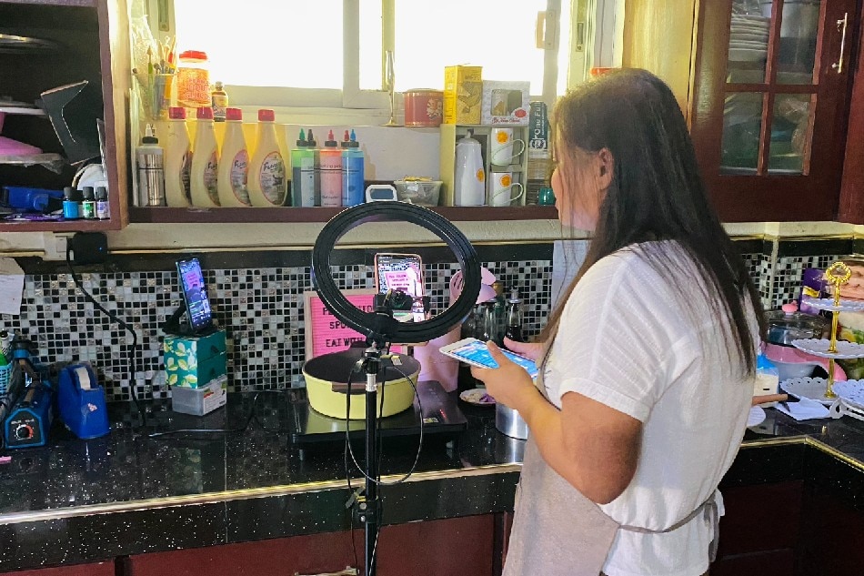 Jemima Nabong prepares food for her family during her live broadcasts.  In a small corner of their dining room, she hosts streams 3 times a week and has started earning income through Kumu.  Wena Cos, ABS-CBN News