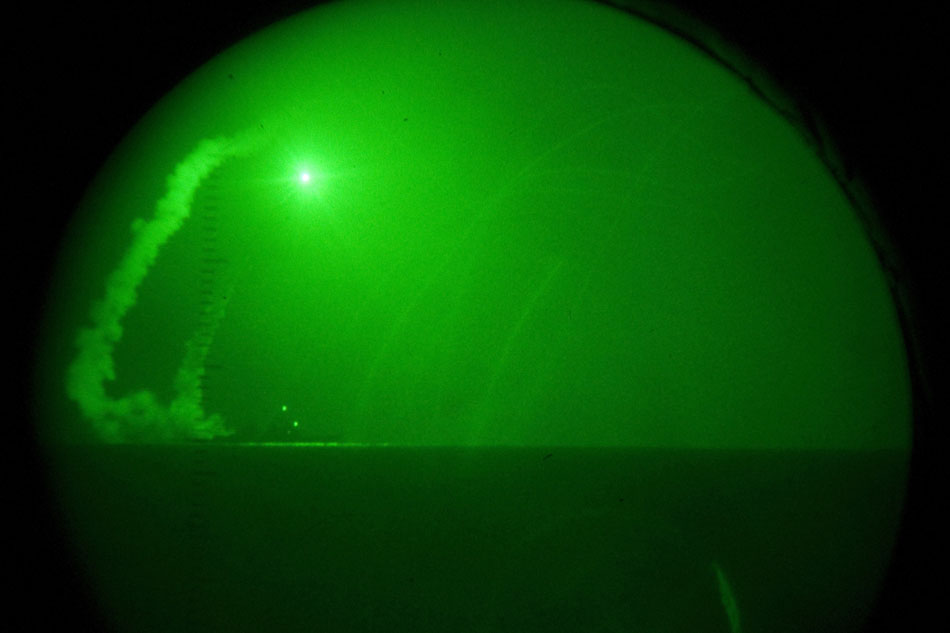 Seen through night-vision lenses aboard amphibious transport dock USS Ponce, the guided missile destroyer USS Barry fires Tomahawk cruise missiles from its position in the Mediterranean Sea, in support of Operation Odyssey Dawn on 19 March 2011. EPA/Nathanael Miller/ US NAVY EDITORIAL USE ONLY