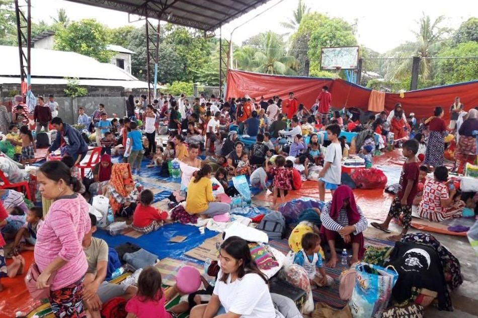 More than a hundred families affected by Tropical Storm Paeng take shelter at Barangay Tamontaka covered court in Datu Odin Sinsuat Municipality in Maguindanao on October 29, 2022. According to Barangay Kagawad Anwar Kasan, the displaced families come from Barangays Badak, Kusiong and Tapian of the same municipality. Kagawad Kasan and his team serve chicken rice porridge or arroz caldo and bread to children for breakfast. Courtesy of Omar Juanday, PonD News Asia