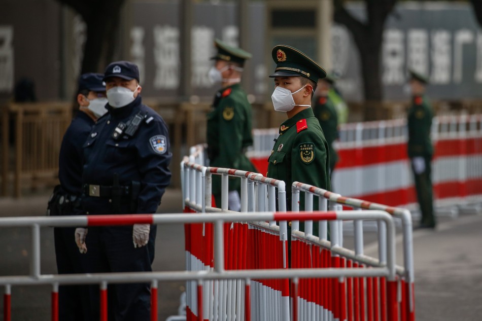 Police and soldiers stand guard during the Beijing Marathon in Beijing, China, Nov. 6, 2022. The Beijing Marathon resumed after a 2-year hiatus following the COVID-19 pandemic. Participants were limited and were required to follow strict COVID-19 protocols before being able to join the race. Mark Cristino, EPA-EFE