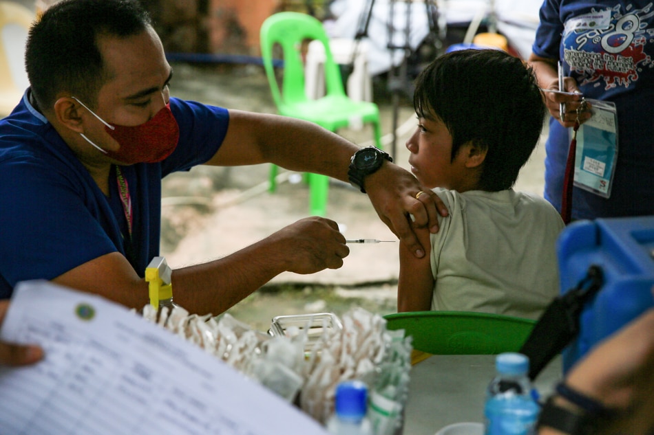 A health worker inoculates a homeless person with a COVID-19 booster shot along Scout Santiago Street in Quezon City on September 29, 2022. Along with the administration of COVID-19 vaccines, the DOH hopes to address other health concerns and issues of the homeless families such as malnutrition and routine immunization. Jonathan Cellona, ABS-CBN News