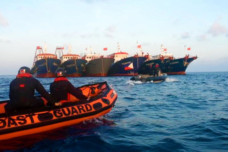  Philippine Coast Guard personnel are seen onboard rubber boats as they sail near Chinese vessels believed to be manned by Chinese maritime militia personnel at Julian Felipe Reef, South China Sea, in a handout photo distributed by the Philippine Coast Guard on April 15, 2021 and taken according to the source either on April 13 or 14, 2021. Handout, Philippine Coast Guard/File 