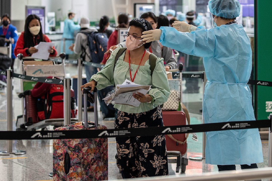 Passengers from the Philippines line up at coach registration desks before undergoing a 7-days hotel quarantine after landing at Hong Kong International Airport in Hong Kong on April 1, 2022. Jerome Favre, EPA-EFE