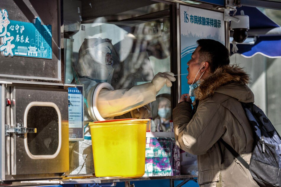 A man takes Coronavirus PCR test in the street booth set to be changed to fever clinics in upcoming days, in Shanghai, China on Dec. 20, 2022. Alex Plavevski, EPA-EFE/File