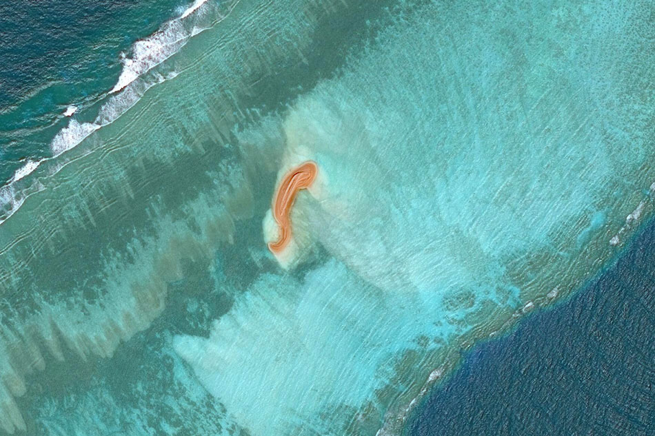 This handout satellite image taken on Nov. 4, 2022 by Maxar Technologies shows a land formation (C) at Eldad Reef in the Spratly Islands, in the disputed South China Sea. The Philippines said on Dec. 21, 2022 it was 'seriously concerned' over a report that China has started reclaiming several unoccupied land features in the disputed South China Sea. Handout/Satellite image ©2022 Maxar Technologies/AFP