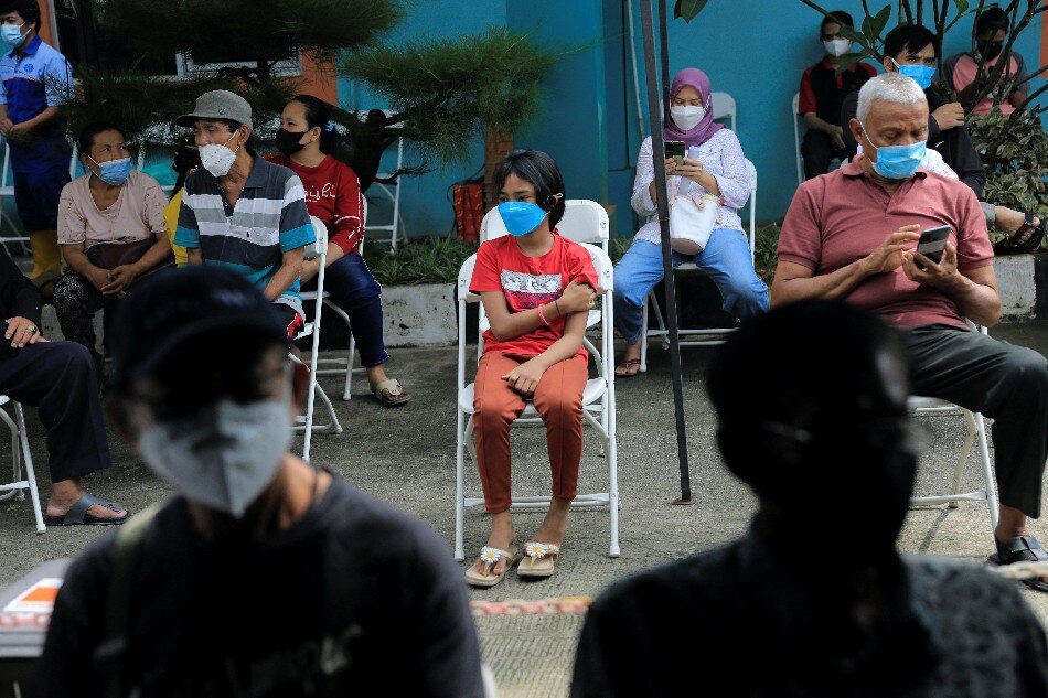 People sit during the observation period after receiving vaccination against COVID-19 at the district health facility, as the country starts the booster vaccination program for the general public, which runs in parallel with the main COVID-19 vaccination program, amid the rise of the omicron variant, in Jakarta, Indonesia, Jan. 12, 2022. Willy Kurniawan, Reuters