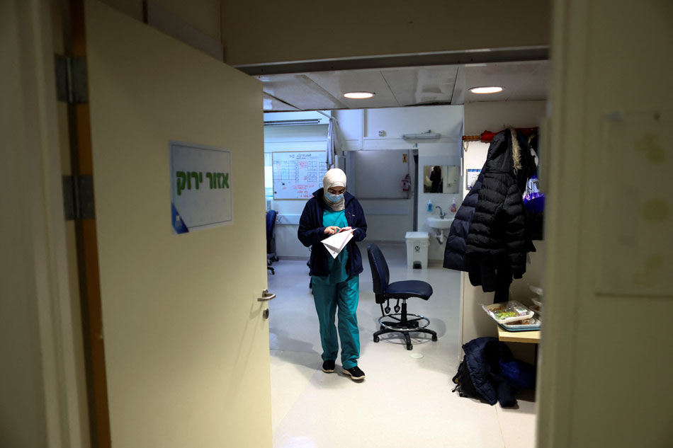 A medical staff member uses her mobile phone in the 