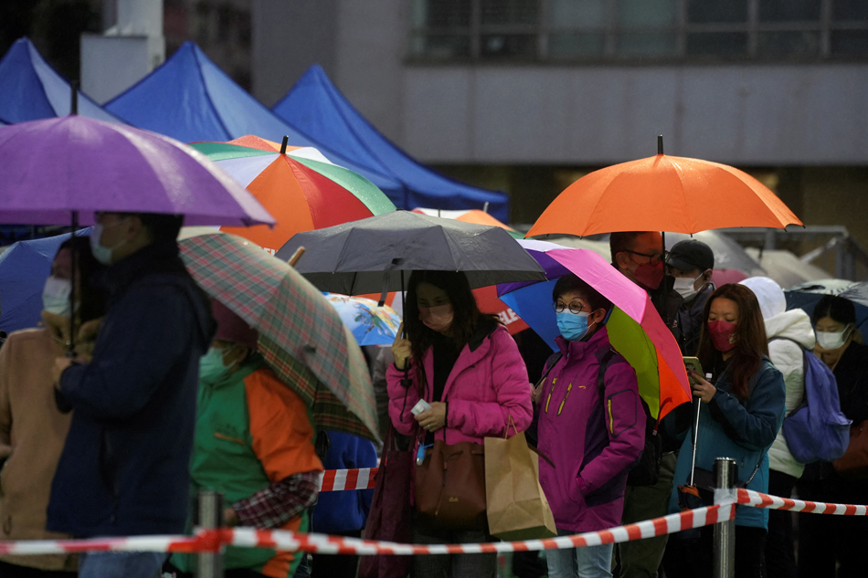 People queue in the rain at a makeshift testing centre for the coronavirus disease (COVID-19) in Hong Kong, China on February 20, 2022. Lam Yik, Reuters/file