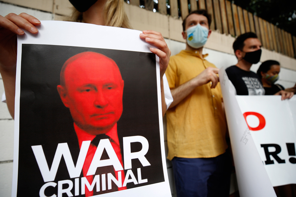 Ukrainian people living in Bangkok hold a photograph depicting Russian President Vladimir Putin during a peaceful demonstration against the Russian invasion of Ukraine, outside the Russian Embassy in Bangkok, Thailand, 28 February 2022. Narong Sangnak, EPA-EFE