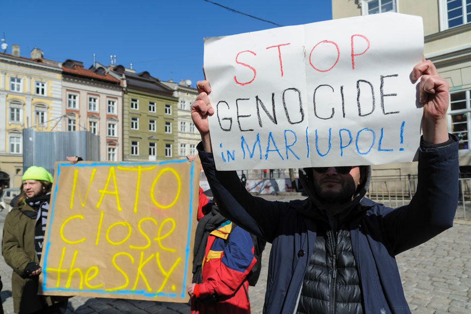People hold placards during a rally to support the city of Mariupol and appeal to NATO to close the sky over Ukraine in downtown of the Western Ukrainian city of Lviv, 19 March 2022. Mykola Tys, EPA-EFE