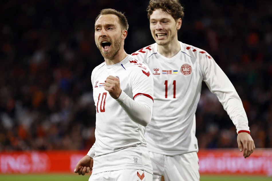 Christian Eriksen (L) of Denmark celebrates with teammate Andreas Skov Olsen after scoring his team