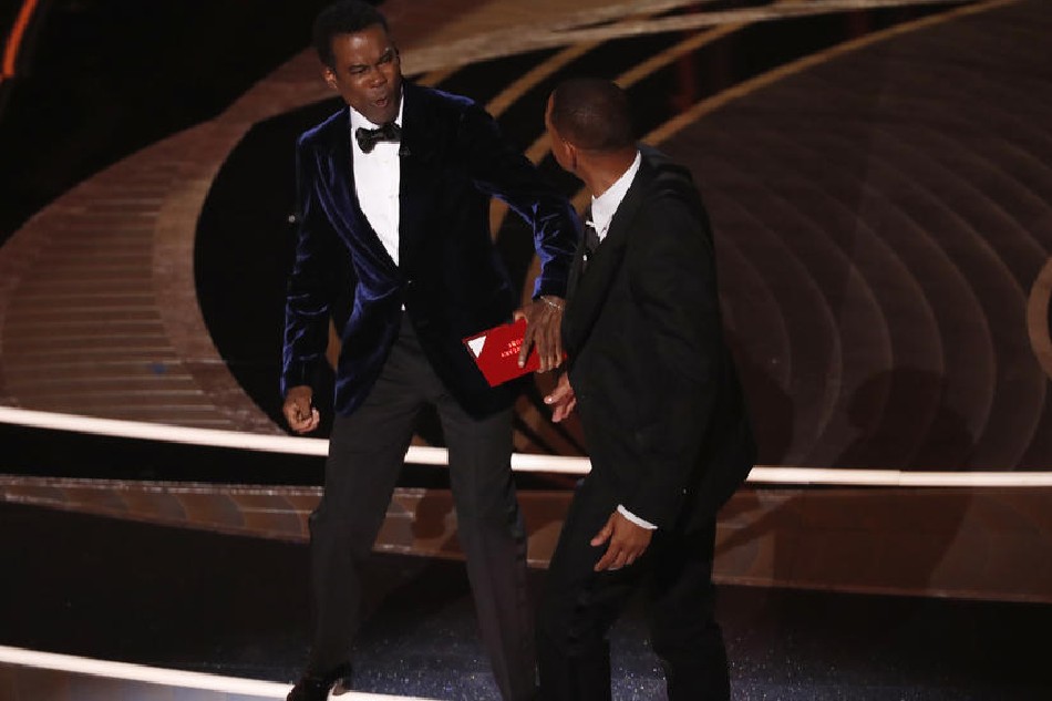 US actor Will Smith (R) swings at actor Chris Rock during the 94th annual Academy Awards ceremony at the Dolby Theatre in Hollywood, Los Angeles, California, USA, on March 27, 2022. The Oscars are presented for outstanding individual or collective efforts in filmmaking in 24 categories. Etienne Laurent, EPA-EFE