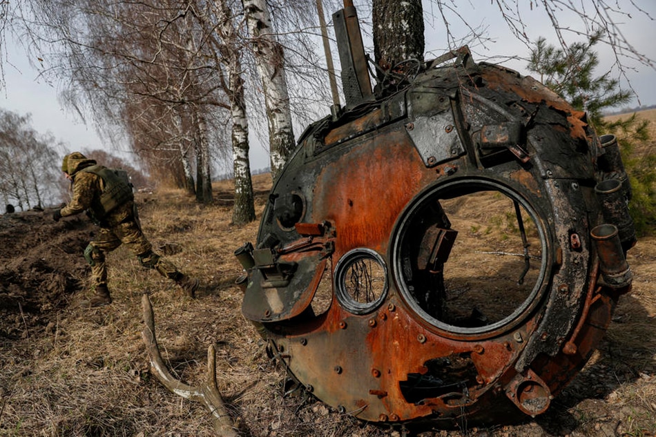 A Ukrainian serviceman inspects the remains of a Russian tank that was damaged in the fighting between Ukrainian and Russian forces on a road leading to the Ukrainian city of Makariv, west of Kyiv, Ukraine, March 31, 2022. Atef Safadi, EPA-EFE