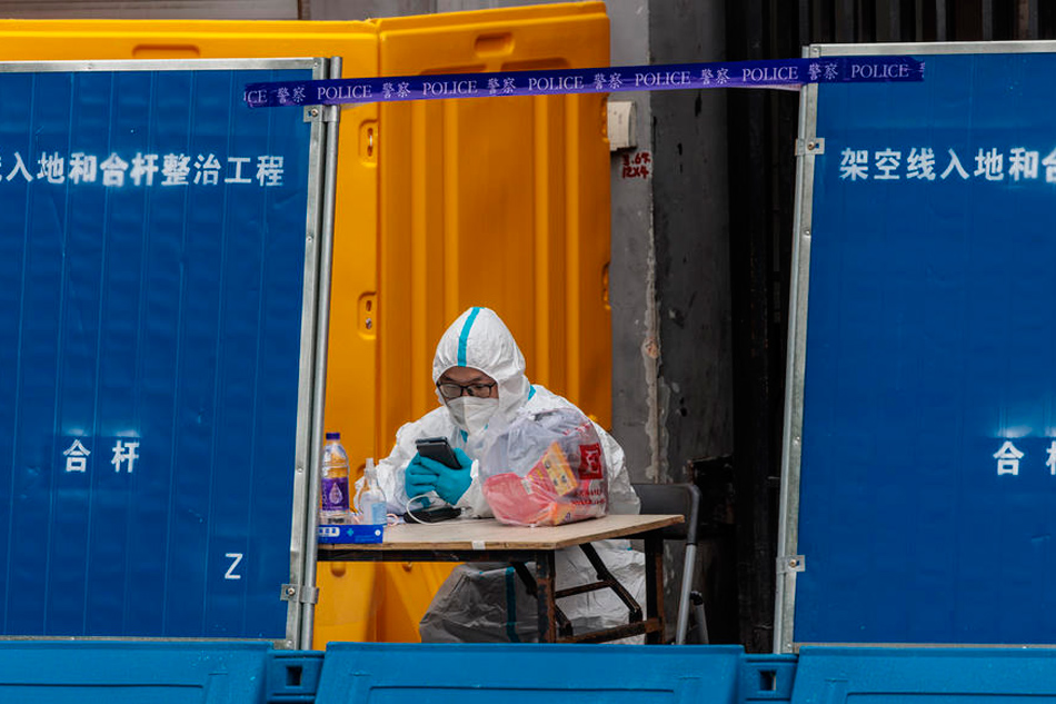 A man wearing protective gear guards in front of the compound under quarantine amid the lockdown, in Puxi side of the city, in Shanghai, China, March 31, 2022. Alex Plavevski, EPA-EFE