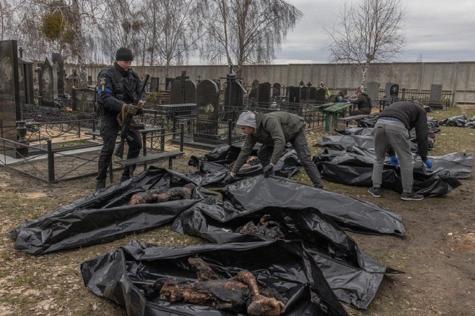 Police officers and forensic personnel check to identify the bodies of killed people, who were brought to the cemetery in Bucha, northwest of Kyiv, Ukraine, April 6, 2022. Hundreds of tortured and killed civilians have been found in Bucha and other parts of the Kyiv region after the Russian army retreated from those areas. Roman Pilipey, EPA-EFE