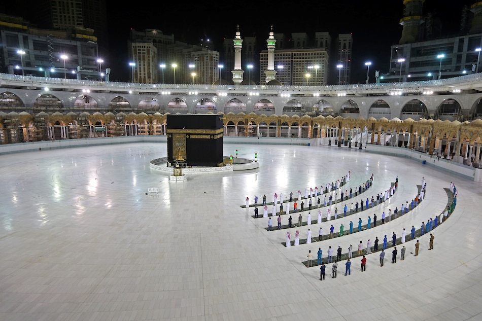 A picture taken June 23, 2020 shows a few worshippers performing al-Fajr prayer at the Kaaba, Islam's holiest shrine, at the Grand Mosque complex in Saudi Arabia's holy city of Mecca. AFP/File