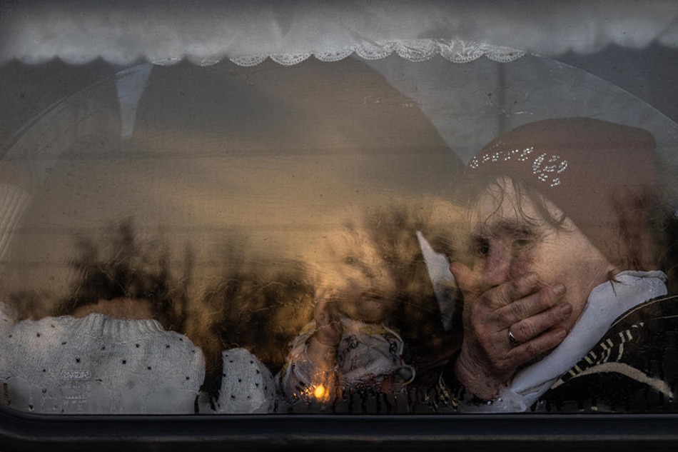 A woman sits with a baby on a bus as they with other people who fled from the besieged by Russian military southeastern city of Mariupol and occupied Melitopol arrive at the evacuation point in Zaporizhzhia, Ukraine, March 25, 2022. EPA-EFE/Roman Pilipey/File