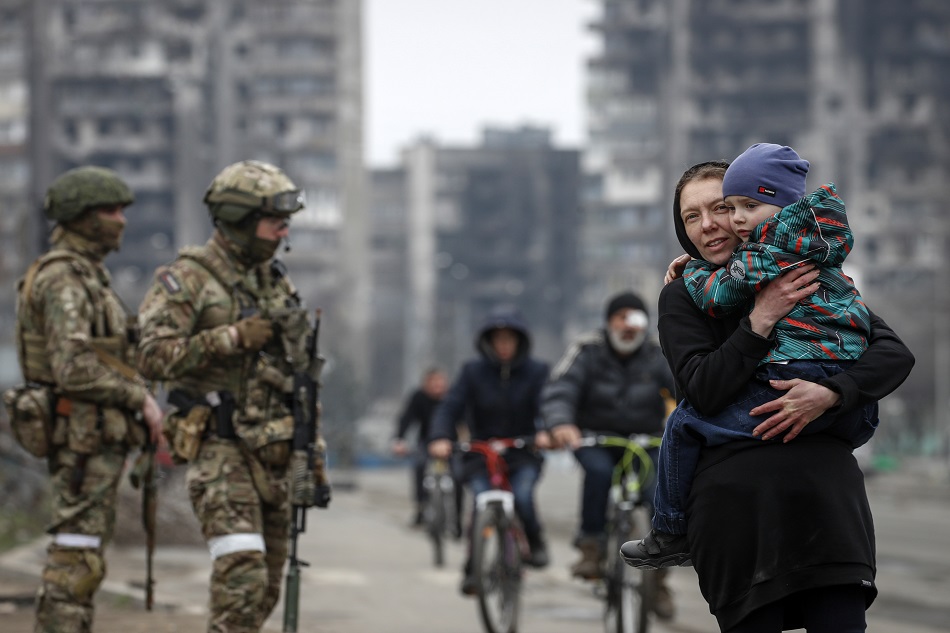 A picture taken during a visit to Mariupol organized by the Russian military shows local people stand in line during distribution of humanitarian aid to local people in Mariupol, Ukraine, April 12, 2022. EPA-EFE/Sergei Ilnitsky