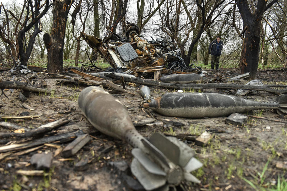 A local man looks at bombs that litter a field in Ivanivka village, Chernihiv region, Ukraine on April 20, 2022. Oleg Petrasyuk, EPA-EFE
