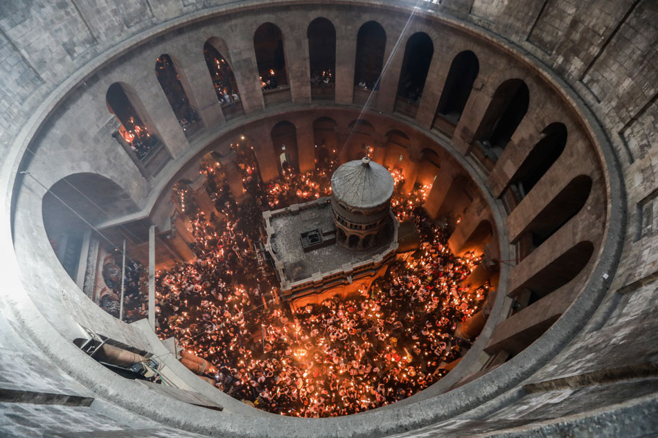 Christian worshippers gather at the Tomb of Christ as they wait for the miracle of the Holy Fire ceremony to occur, in the Church of the Holy Sepulchre, in Jerusalem, Israel on April 22, 2022. Eastern Orthodox Christians believe that the Holy Fire, which emanates from within the Tomb of Christ, spontaneously lights other lamps and candles around the church and reaches Jerusalem and even foreign countries. The fire represents the flame of the resurrection power. EPA-EFE/Abir Sultan, file