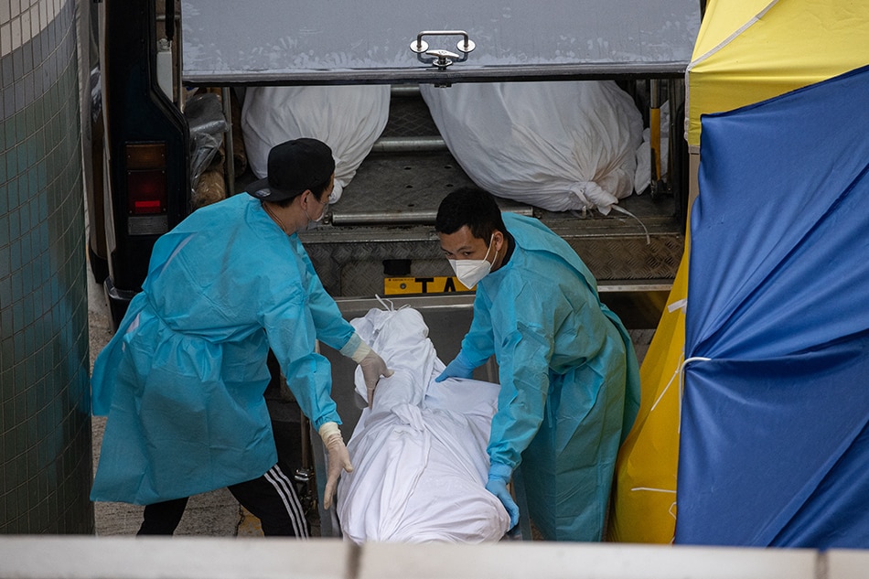 Funeral home staff load a dead body into a van outside the Caritas Medical Center in Hong Kong, China, March 2, 2022. Jerome Favre, EPA-EFE