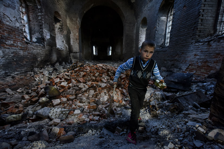 A local boy named Alexander, walks in the remains of the Church of the Ascension built in 1913 and destroyed during the Russian occupation of Lukashivka village, Chernihiv region, April 27, 2022. Oleg Patrasyuk, EPA-EFE 