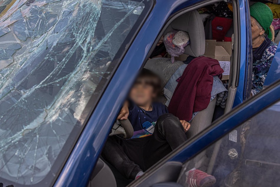 A boy plays in a car with a broken front window after arriving from Mariupol at the evacuation point in Zaporizhzhia, Ukraine on May 2, 2022. Roman Pilipey, EPA-EFE