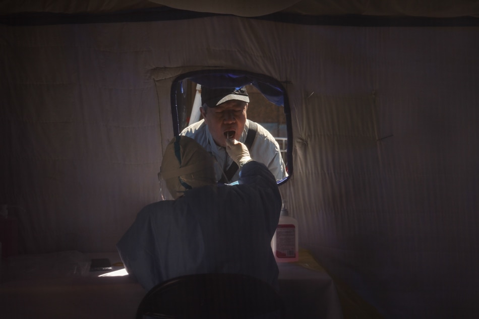 A man undergoes a COVID-19 test at a makeshift tent in Beijing, China on Friday. Mark R. Cristino, EPA-EFE
