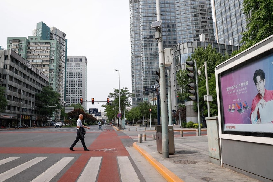 A man crosses a road in the central business district of Beijing, China, on May 5, 2022. Mark R. Cristino, EPA-EFE