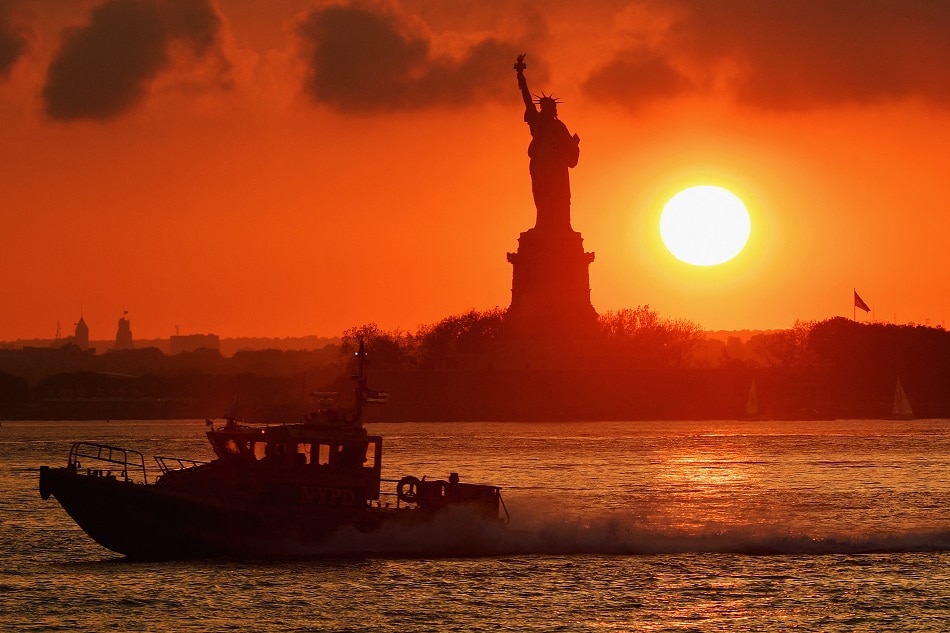 An NY Police Department boat passes by, as the sun sets behind the Statue of Liberty on June 11, 2020 in New York City. Angela Weiss, AFP/file