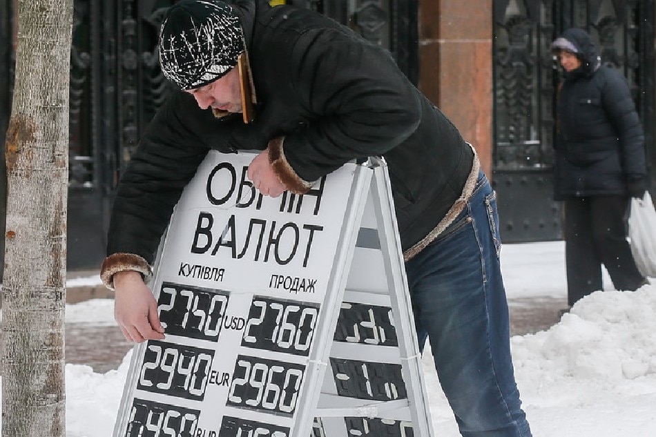 An employee of an exchange office replaces numbers on the rate board in downtown Kiev, Ukraine, 07 February 2017. SERGEY DOLZHENKO, EPA-EFE/File