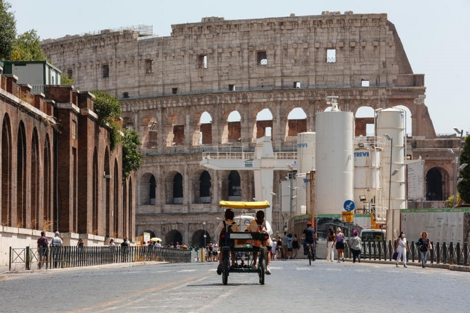 Two people on a rickshaw drive along Via dei Fori Imperiali road in front of the Colosseum amphitheater in central Rome, July 31, 2021. Giuseppe Lami, EPA-EFE