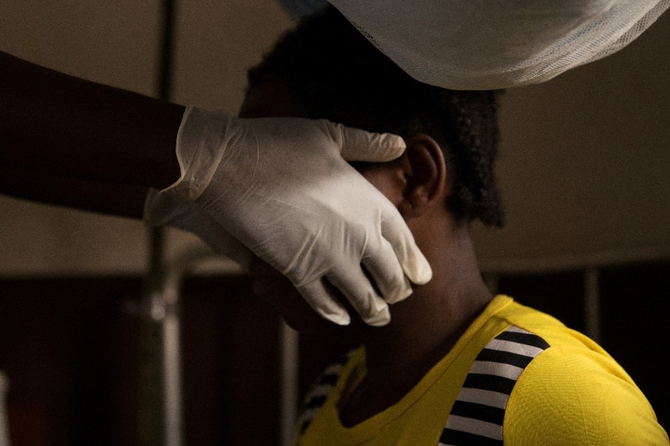 A doctor examines a woman infected with monkeypox at a quarantine area of the centre of the International medical NGO Doctors Without Borders (Medecins sans frontieres - MSF), in Zomea Kaka, in the Lobaya region, in the Central African Republic on October 18, 2018. Monkeypox is a contagious disease, without remedy, which heals itself, but who can kill if not treated in time. Since May 2018, the monkeypox virus, which spreads in tropical Africa, has become a 'public health threat' in the Central African Republic, according to the Pasteur Institute of Bangui. CHARLES BOUESSEL / AFP