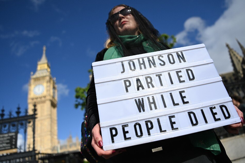 A protester demonstrates against the Downing Street parties, outside parliament in London, Britain, 25 May 2022. British Prime Minister Boris Johnson is under pressure over 'party gate' allegations following new photographs showing him at a drinks party during lockdown. EPA-EFE/ANDY RAIN