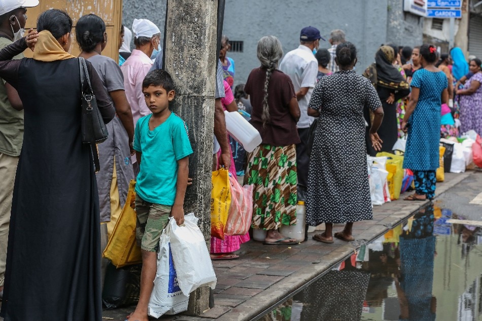 People wait to buy fuel at a gas station amid a fuel shortage in Colombo, Sri Lanka, May 24, 2022. Sri Lanka raised petrol prices by 24.3 percent and diesel by 38.4 percent on May 24 amid the country's worst economic crisis in decades due to the lack of foreign exchange, resulting in severe shortages in food, fuel, medicine, and imported goods. Protests have been rocking the country for weeks, calling for the resignation of the president and government over the alleged failure to address the worsening current economic crisis. Chamila Karunarathne, EPA-EFE